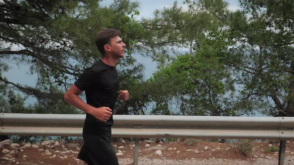 Male runner running on forest road