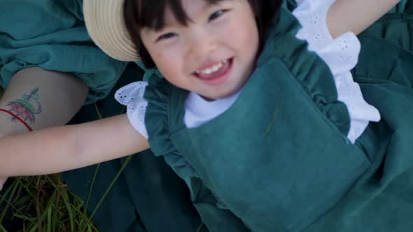 Koreans Family Mother and Daughter in Green Dresses Sitting in the Long Grass