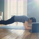 Strong Woman Stands in Plank Pose Watching Video on Laptop - VideoHive Item for Sale