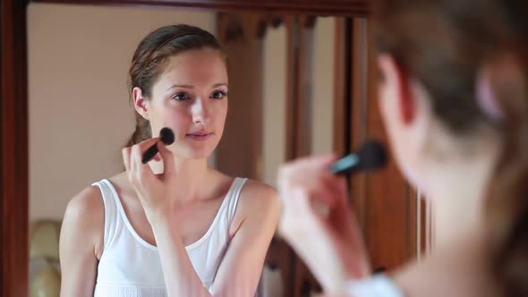 Beautiful Woman at the Mirror Applying Make Up