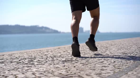 Mature Man in Shorts and Sneakers Running at Riverside