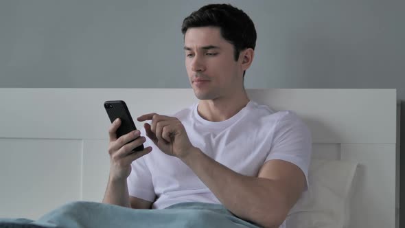 Young Man Browsing Smartphone Using Internet