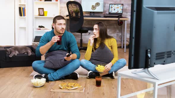 Couple Sitting on the Floor Watching Tv