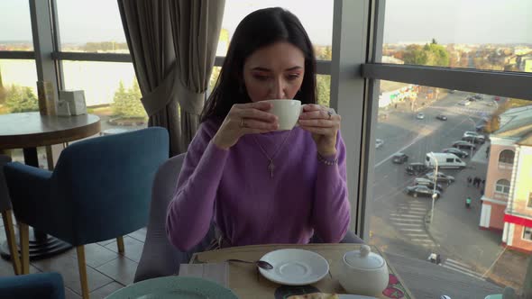 Girl Drinks Coffee In Cafe