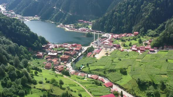 aerial drone revealing a beautiful lake and mosque in the center of a mountain village located in Uz