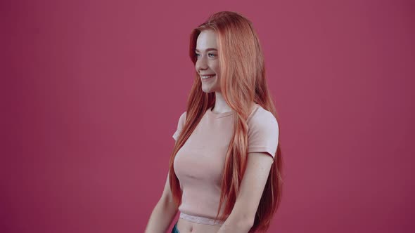 Young Redhead with Her Hand on the Cure in Profile Sideways to the Left in a Pink Casual Tshirt