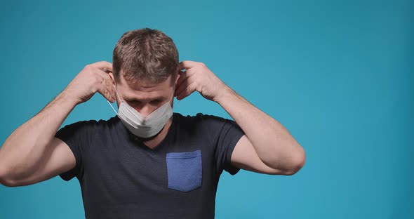 Guy with Beard Puts Disposable Medical Mask on and Breathes