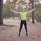 Young Male Runner Warms Up Before Jogging in Pine Forest - VideoHive Item for Sale