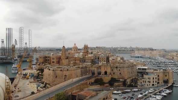 Fort Saint Elmo in the Port of Valetta, in Malta - Ascending Reveal aerial shot