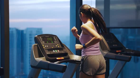 Young beautiful woman asian running on a treadmill at gym.