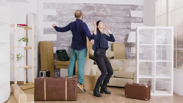 Happy Young Couple Jumping in Their New Apartment