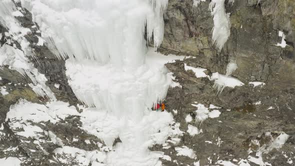 Extreme mountain climbers on frozen cascade ledge dynamic aerial