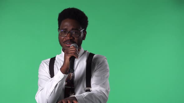 Portrait of Young African American Man Singing Happily Into the Microphone and Gesturing with His