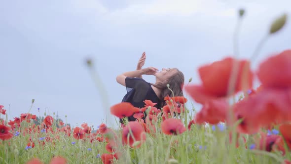 Pretty Girl Dancing in a Poppy Field Smiling Happily