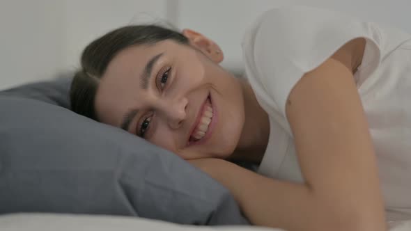 Happy Hispanic Woman Smiling while Laying in Bed, Side Pose