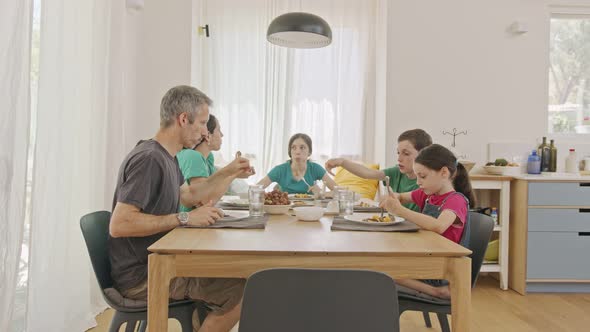 Family eating pancakes and fruits for breakfast