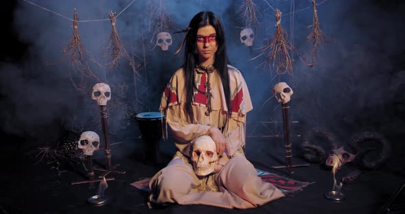 Woman in Traditional Native American Clothes Is Sitting with a Skull, Smoke, 