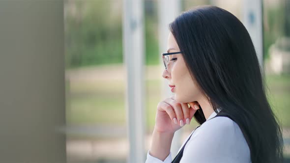 Pensive Stylish European Businesswoman in Glasses Thinking and Holding Hand Near Chin