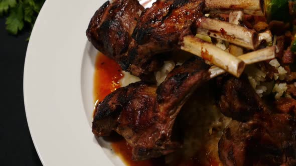 Overhead view of lamb chops with fork picking up rice.