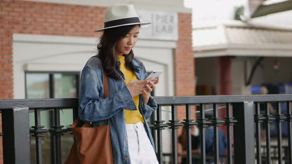 Beautiful Asian girl using smartphone at community mall.