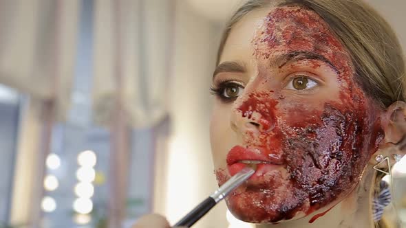 Make-up artist make the girl halloween make up in studio.