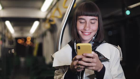 Portrait of Smiling Beautiful Young Woman in Headphones Riding in Public Transport, Listen Music and