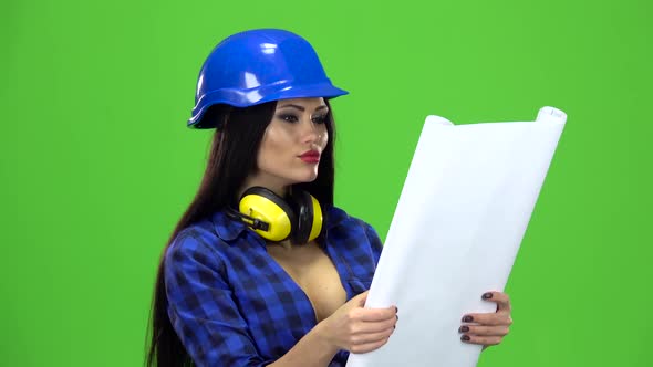 Woman in the Blue Plaid Shirt with a Drawing in the Hands of Smiling on Green Background