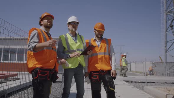 Builders Discussing Power Plant Construction