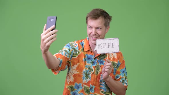 Young Handsome Tourist Man Taking Selfie with Paper Sign