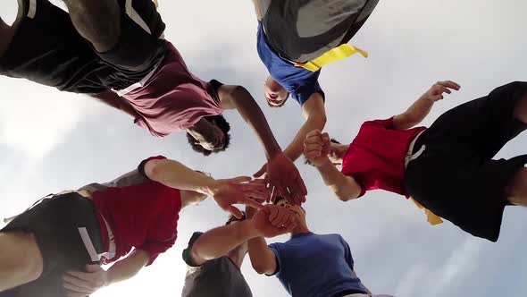 A group of young men playing flag football on the beach.