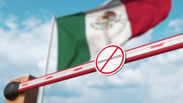 Opening Boom Barrier with Stop Immigration Sign at the Mexican Flag