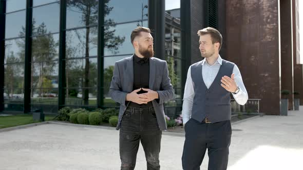 Young Beard Businessmen Walking and Talking About Business in Crises. Business Building Background.