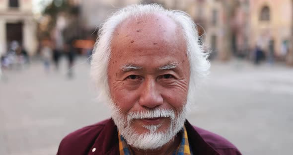 Asian senior man smiling on camera outdoor