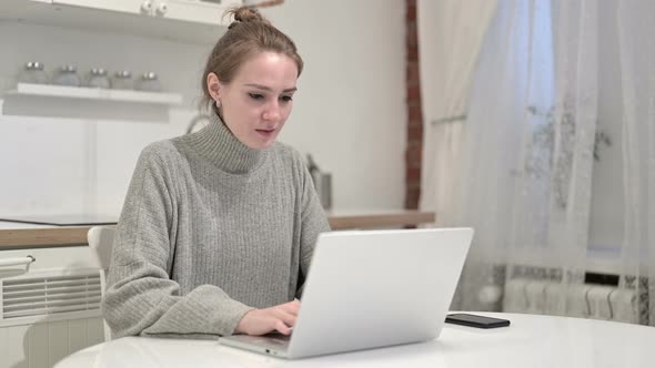 Ambitious Young Woman Celebrating Success at Home