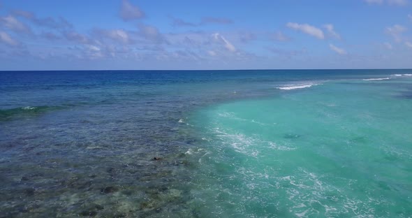 Wide angle drone abstract view of a white paradise beach and blue ocean background in vibrant 4K