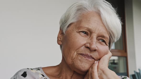 Thoughtful Senior Woman with Smile Looking in the Distance. Portrait with Copy Space