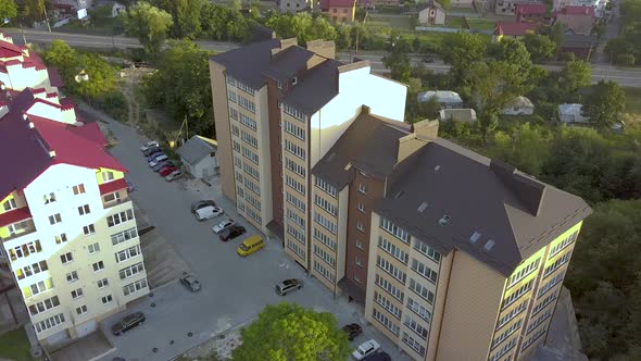 Aerial view of multistory apartment building in green residential area.