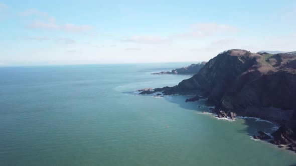 Overlooking The Blue Calm Water By The Coast Near Ilfracombe In North Devon England. - Aerial Drone