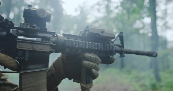 Modern Soldier with Rifle in Dens Forest with Smoke in Backgorund