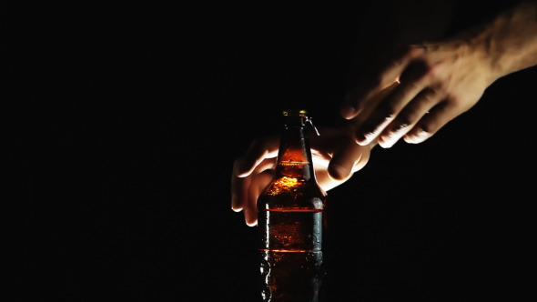Hand Opens bottle And Pours Beer Into a Glass