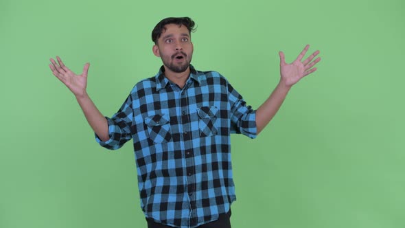 Happy Young Bearded Persian Hipster Man with Surprised Gesture