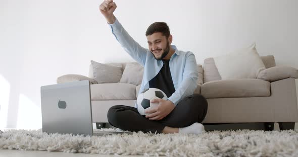 A Young Indian Football Fan is Watching TV at Home