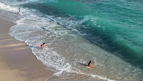 A young girl happily fights with the waves aerial view 4 K