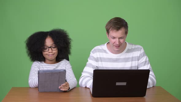 Young African Girl and Young Scandinavian Man Using Gadgets Together