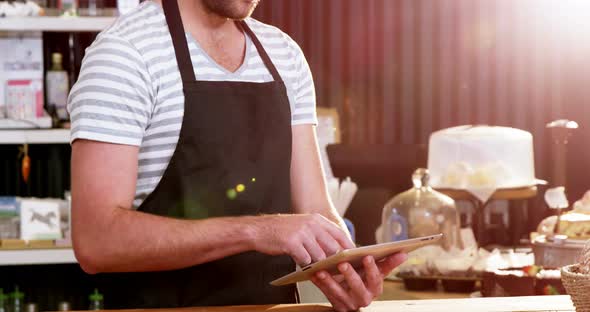 Male waiter using digital tablet