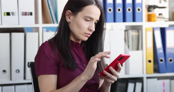 Concentrated Woman Looks at Smartphone and Texts Closeup