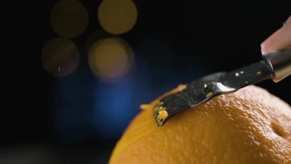 Macro Shot Peeling citrus orange, oil particles being release in Slow motion, Blurred Background