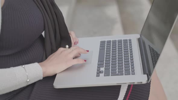 Close Up Shot Of A Woman Typing On A Laptop Outside In Slowmotion - Ungraded