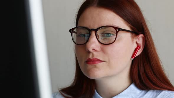 Business Woman in Wireless Headphones Watching a Webinar Listening to a Lecture Online at Home