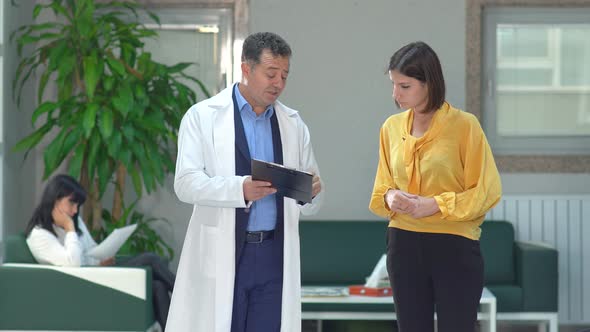 Doctor and patient relative, hospital corridor.